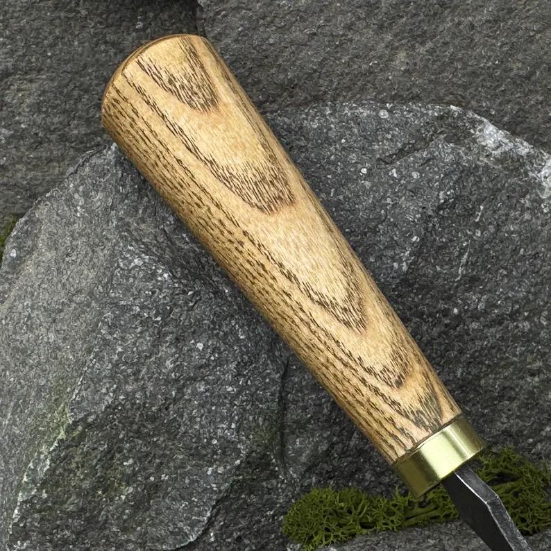 This hand-forged scorpion knife features a carbon steel 52100 blade and comes with a leather case. It’s perfect for bowl, cup carving, spoon