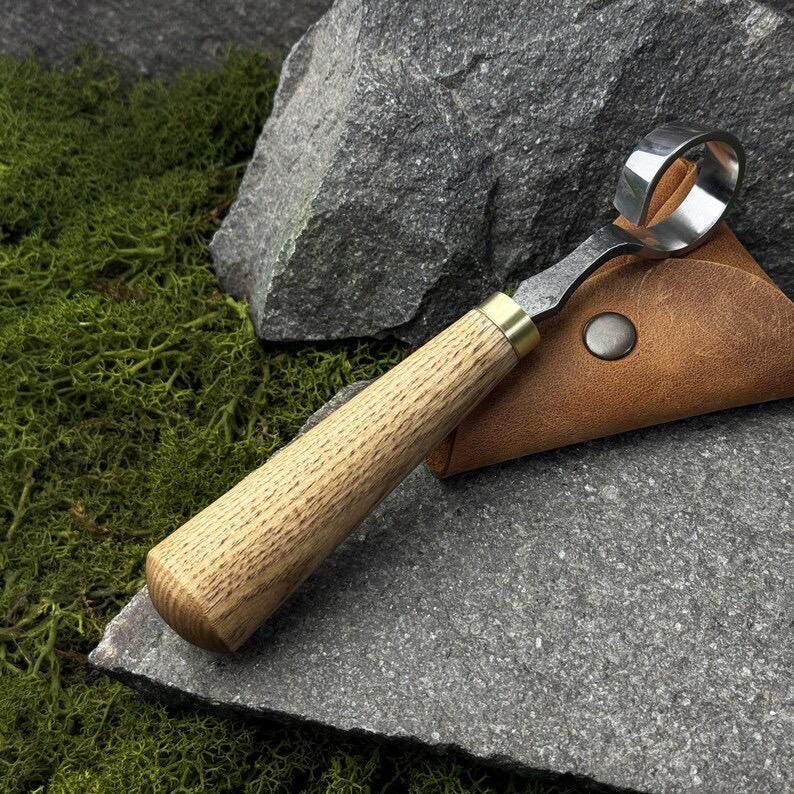 This hand-forged carbon steel 52100 knife is a woodworking beginner’s tool. It’s a wood carving scorp knife with a leather case and includes
