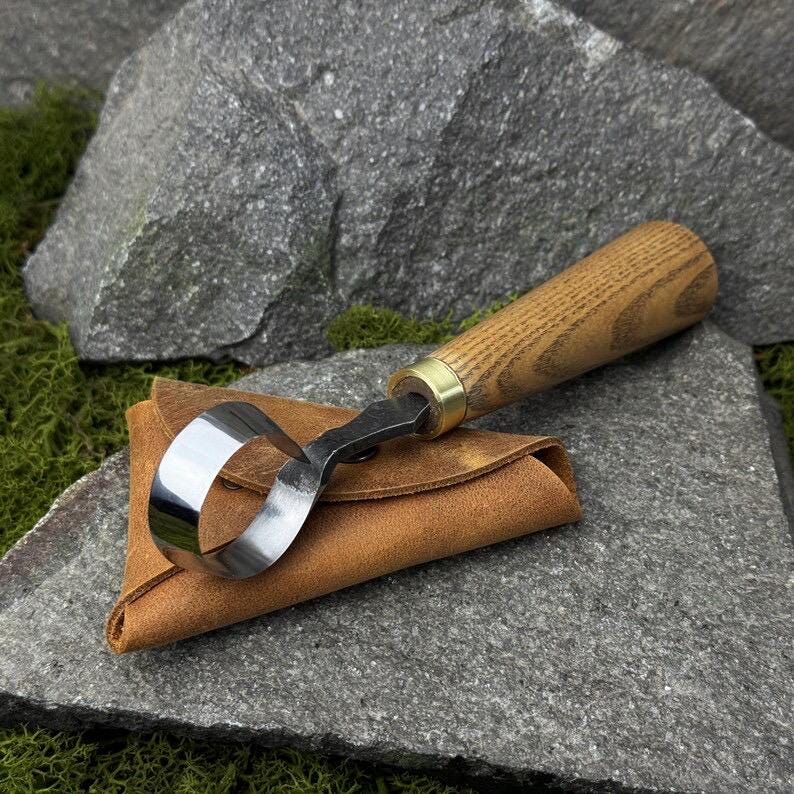 This hand-forged carbon steel 52100 knife is a woodworking beginner’s tool. It’s a wood carving scorp knife with a leather case and includes